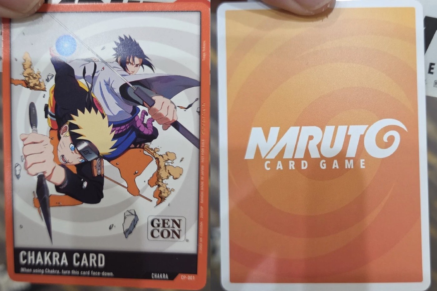 Naruto Card Game CP-001 Chakra Card Gen Con 2026 promo, front and back — Naruto and Sasuke art, orange NARUTO CARD GAME reverse